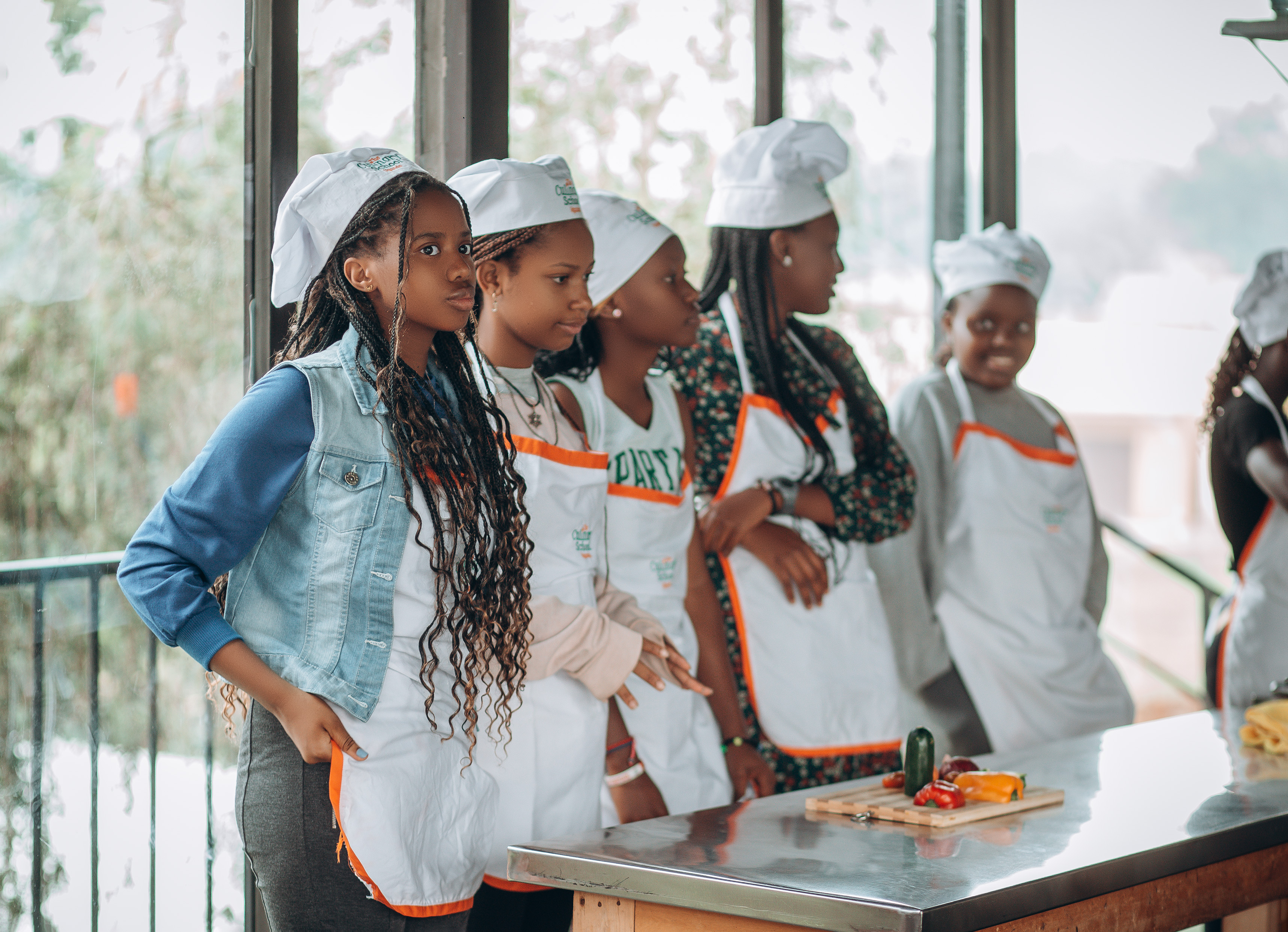 Back of a man at a concert. Hes wearing a beanie hat and a baggy denim jacket with studs. Photo with a purple hue