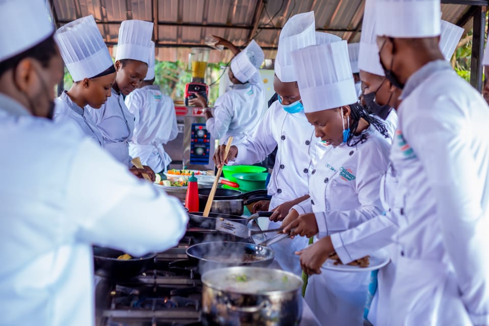 Back of a man at a concert. Hes wearing a beanie hat and a baggy denim jacket with studs. Photo with a purple hue